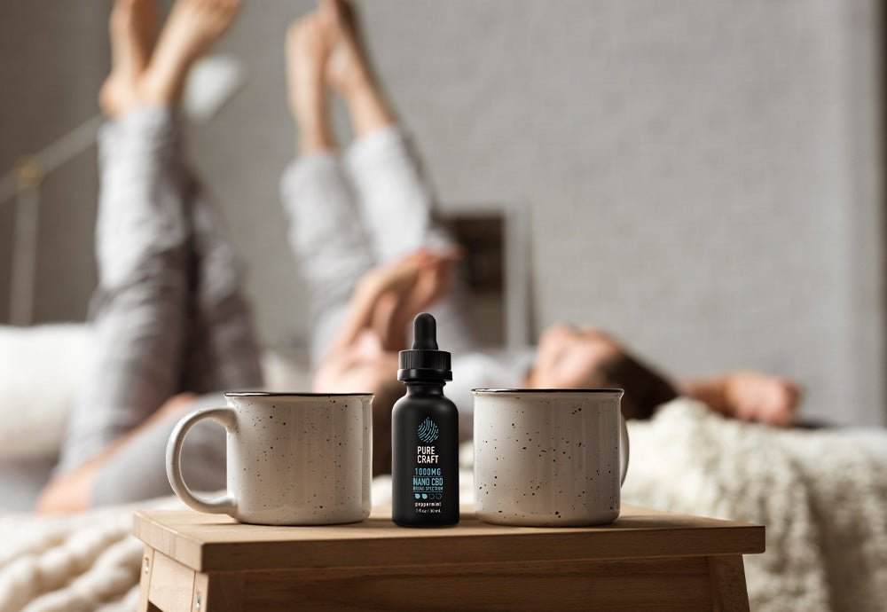 happy couple in bed cbd oil bottle on side bed table